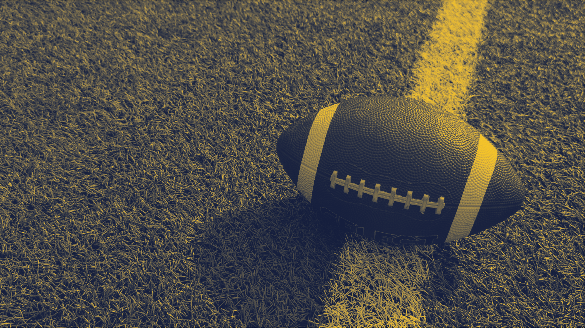 Football resting on the field next to a yard line