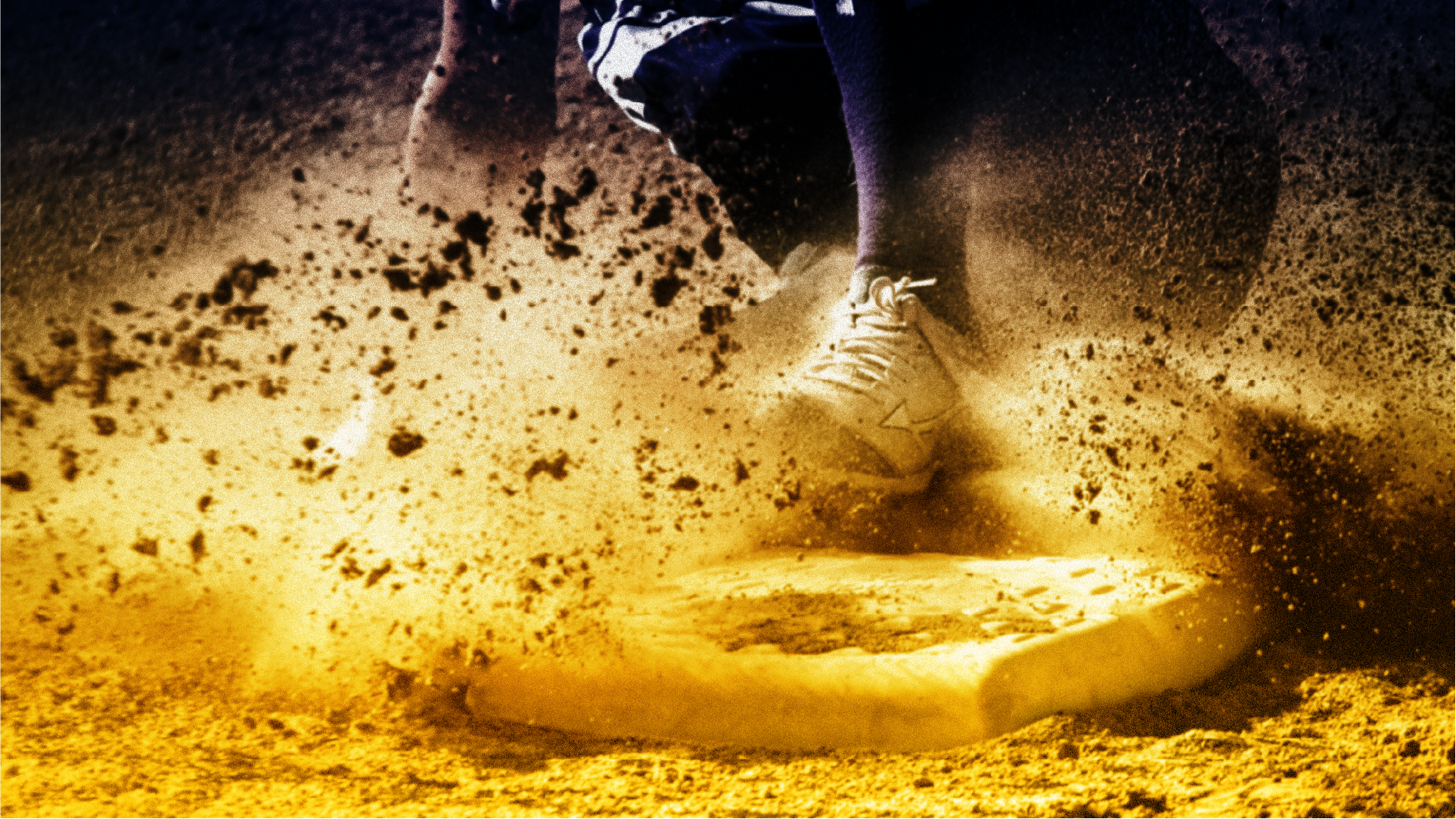 Runner sliding into the bag, dirt kicking up under stadium lights