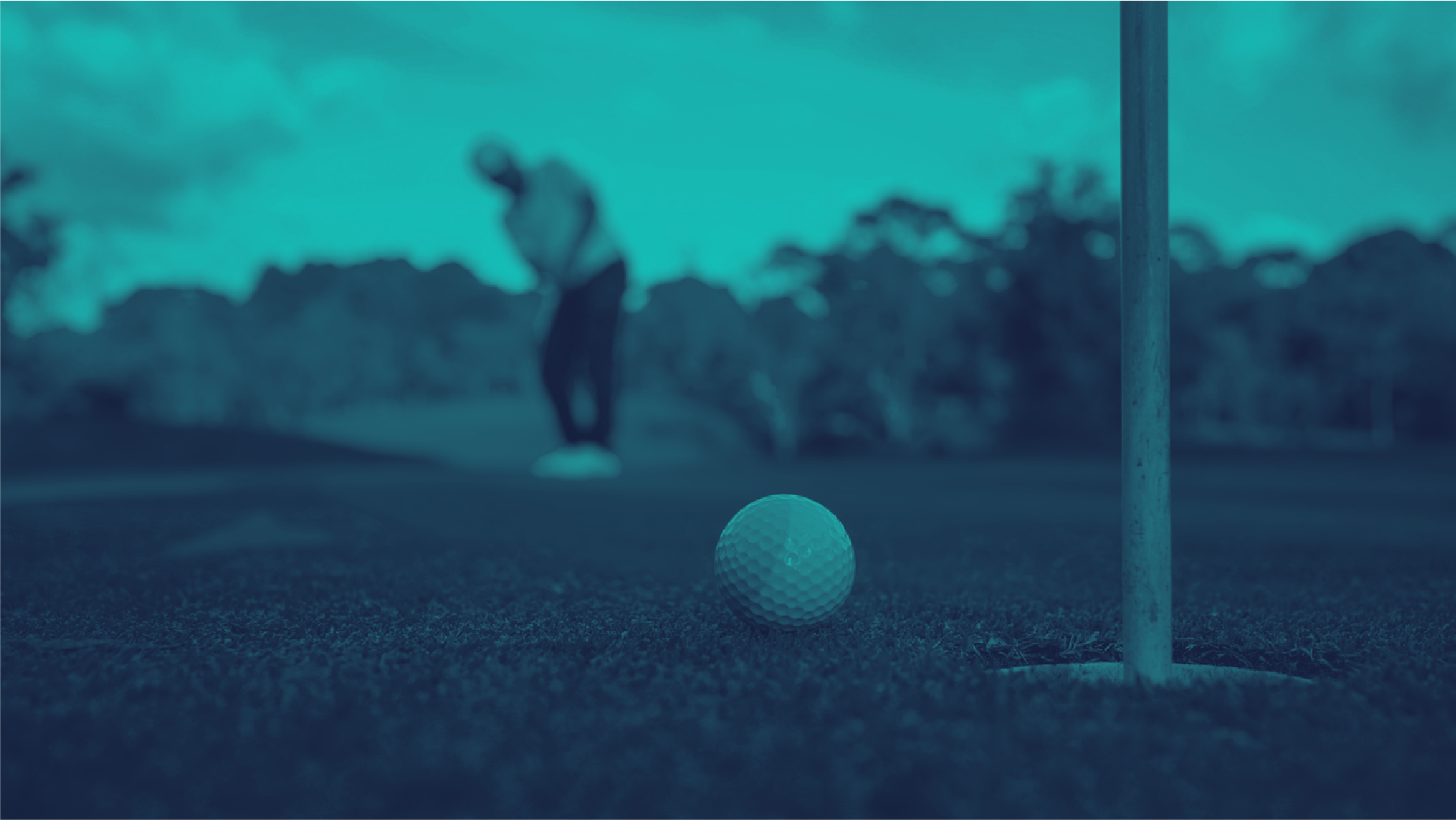 Golf ball at the hole with golfer mid-swing in the background